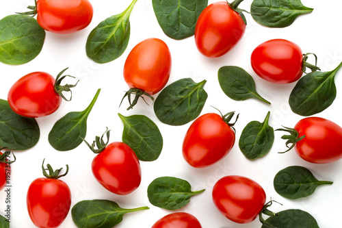 Spinach and tomato pattern background on white. Top view