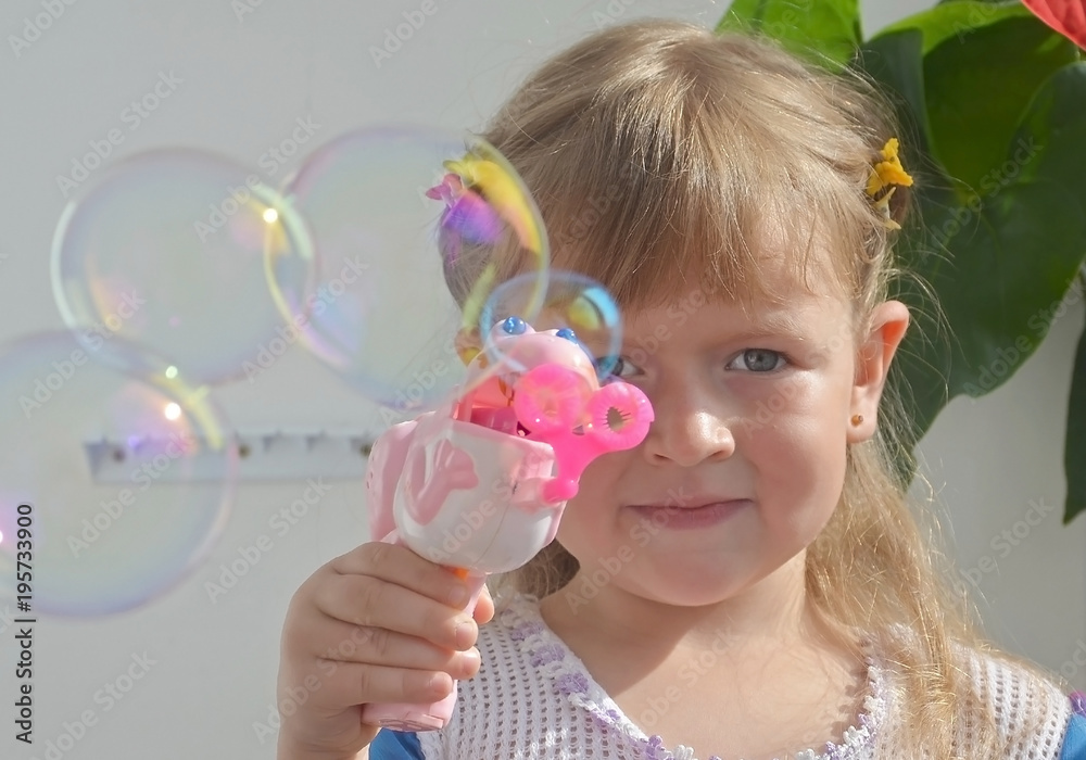 little girl blowing bubbles on the balcony in the sun little girl blowing bubbles on the balcony in the sun