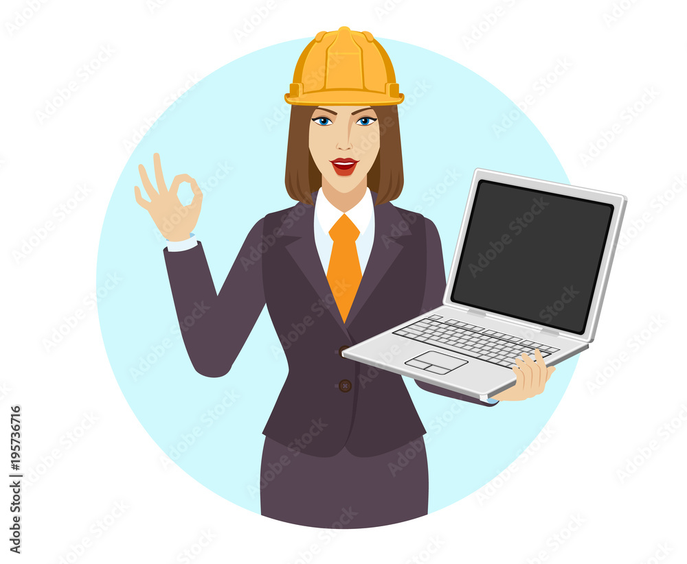 Businesswoman in construction helmet holding a laptop notebook and show a okay hand sign Businesswoman in construction helmet holding a laptop notebook and show a okay hand sign