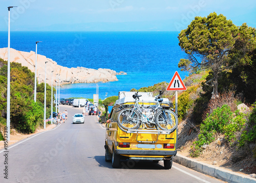 Van with bicycle on road at Capo Testa Sardinia photo