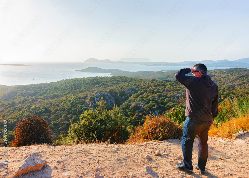 Man looking at sunrise in Costa Smeralda resort Mediterranean sea