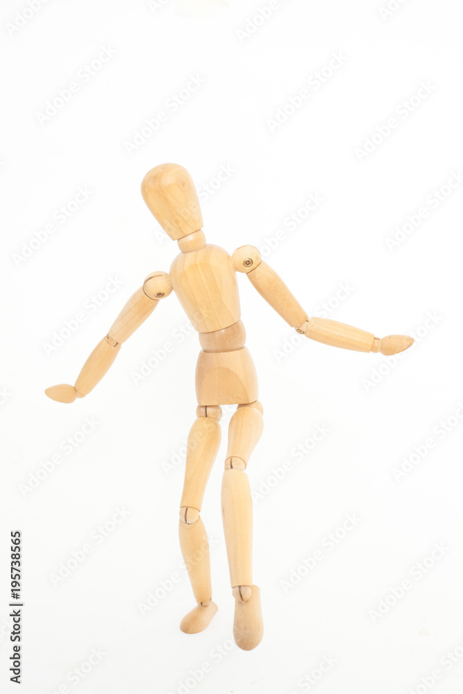 The wooden mannequin steps uncertainly. On a white background. The wooden mannequin steps uncertainly. On a white background.
