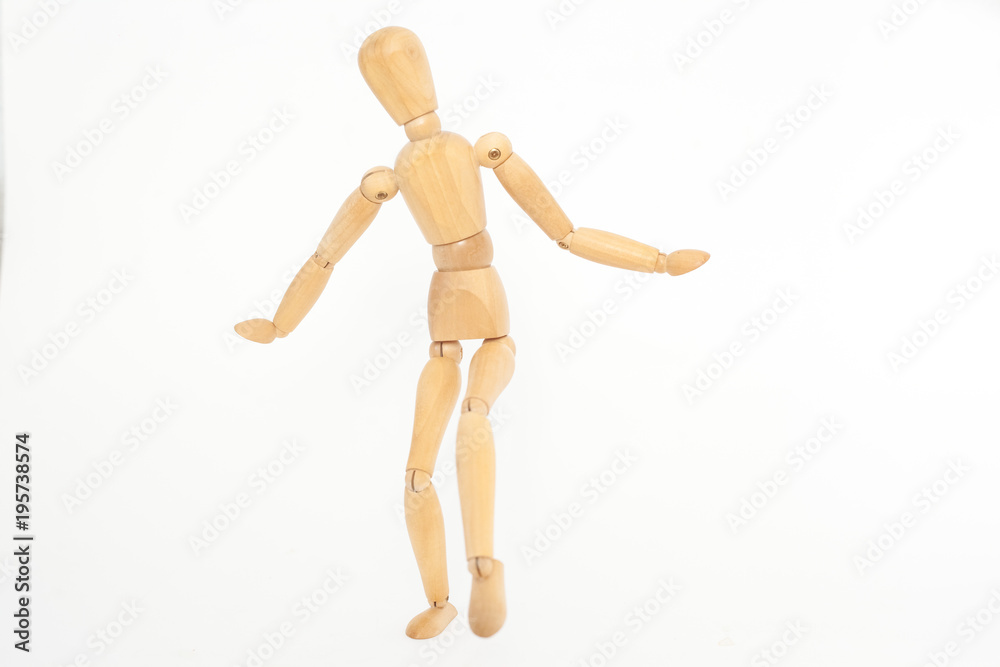 The wooden mannequin steps uncertainly. On a white background. The wooden mannequin steps uncertainly. On a white background.