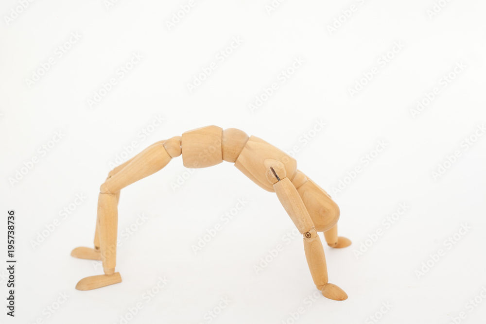 A wooden manicure performs exercises of gymnastics. On a white background. A wooden manicure performs exercises of gymnastics. On a white background.