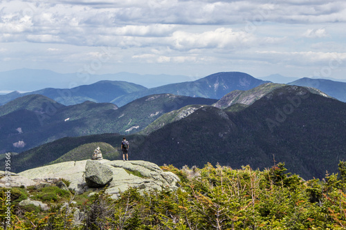 Hiker walking on beautiful mountain path with sweeping views into the Adirondack high peaks in New York photo