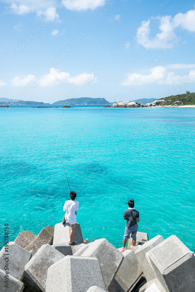 Fototapeta premium Tetrapods und Angler am Aharen Strand auf Tokashiki, Okinawa, Japan
