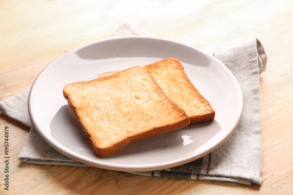 Plate with tasty toasted bread on wooden table Plate with tasty toasted bread on wooden table