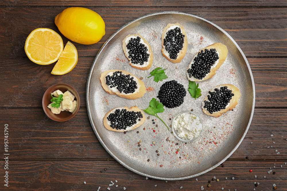 Sandwiches with delicious black caviar on metal tray