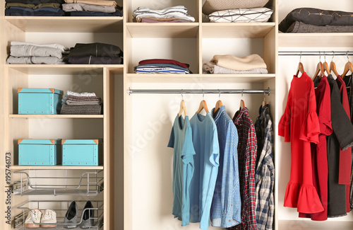 Large wardrobe closet with different clothes and shoes © Africa Studio