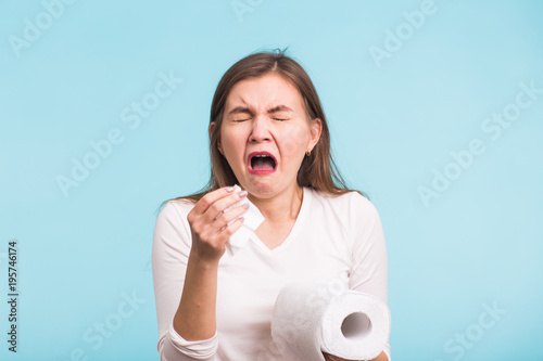Woman Sneezing Studio Portrait Concept on blue background photo
