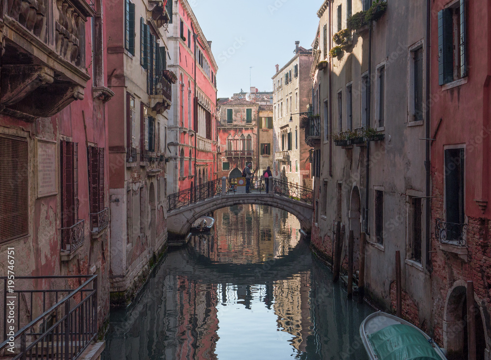 small canal of Venice with ancient buildings with peeling walls that preserve their charm. Italy