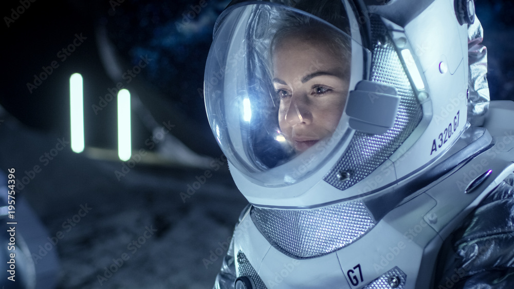 Female Astronaut Wearing Space Suit Works on a Laptop, Exploring Newly Discovered Planet, Communicating with the Earth. In the Background Her Crew Member and Living Habitat. Colonization Concept.