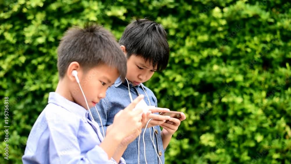 Young Asian boy play game on smartphone Young Asian boy play game on smartphone