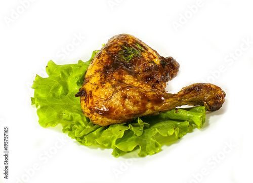 Fried chicken leg with lettuce leaves on white isolated background.