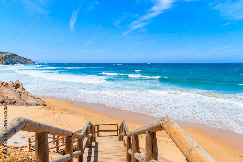 Walkway to Amado beach with beautiful sea waves, Algarve, Portugal