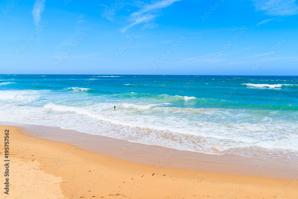 A view of sandy Praia do Amado beach and sea with waves, Portugal