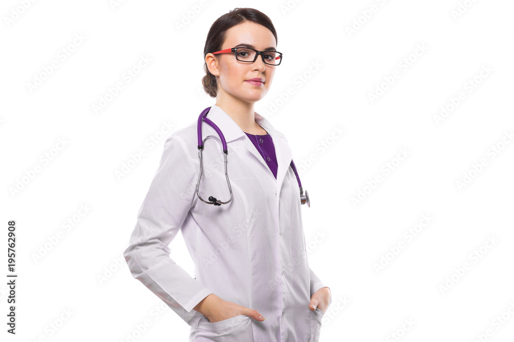 Young woman doctor with stethoscope holding her hands in pockets in white uniform on white background Young woman doctor with stethoscope holding her hands in pockets in white uniform on white background