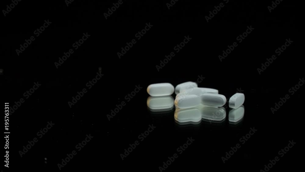 White tablet on a mirror table on a black background White tablet on a mirror table on a black background