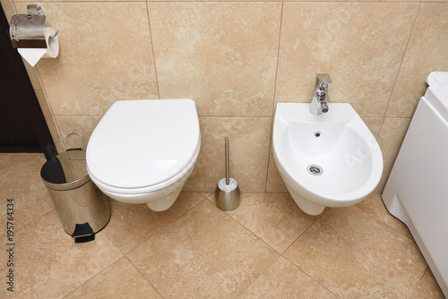 Foto Beautiful bathroom with bidet and toilet bowl in white color