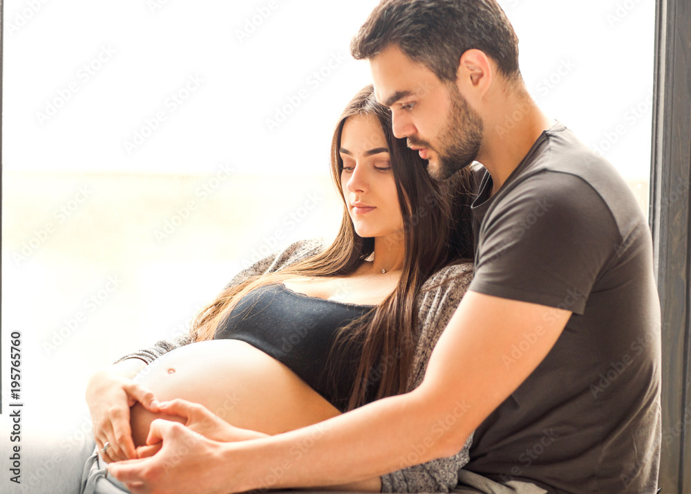 Naklejka premium Couple in love pregnant cuddling, waiting for baby