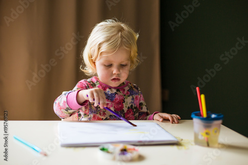 little girl draws paints