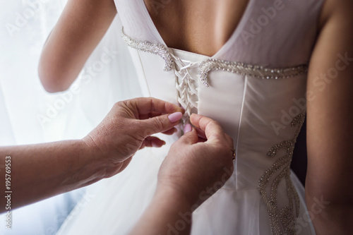 Morning of the bride when she wears a beautiful dress, woman getting ready before wedding ceremony