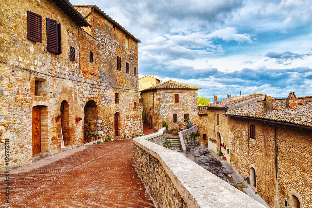View of cozy paved street in San Gimignano, Tuscan medieval town, iconic landmark and popular travel destination in Italy, Europe.