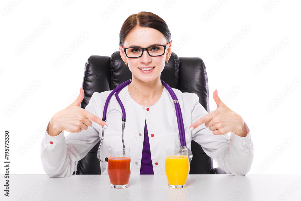 Female nutritionist sitting in her working place showing and offering glass of tomato and orange fresh juice on white background Female nutritionist sitting in her working place showing and offering glass of tomato and orange fresh juice on white background