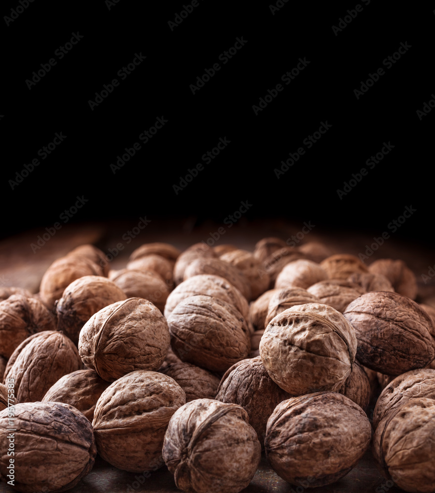 Walnuts large closeup group in peel on dark background Walnuts large closeup group in peel on dark background