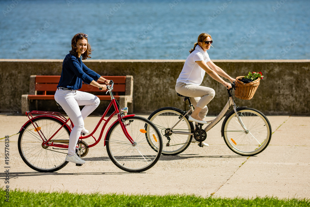 Fototapeta premium Women biking on pier