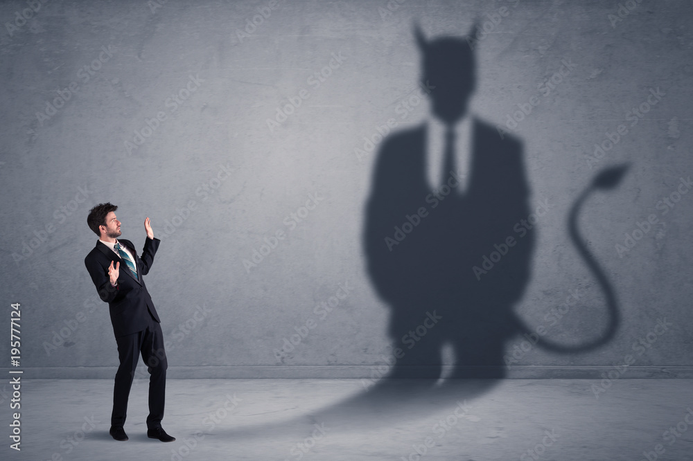 Fototapeta premium Business man looking at his own devil demon shadow concept