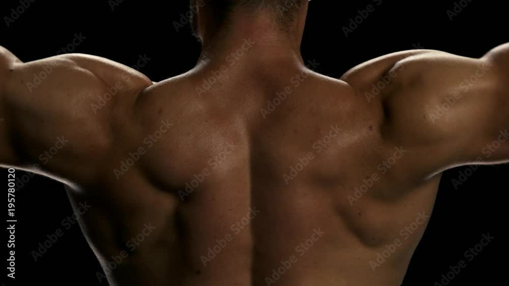 Close up mans lifting dumbbels, back view. Sportsman having workout at gym. Close up on bicep muscles of a professional bodybuilder. Close up mans lifting dumbbels, back view. Sportsman having workout at gym. Close up on bicep muscles of a professional bodybuilder.
