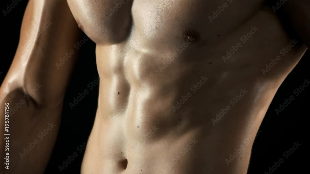 Naked muscular torso of fitness man. Close up wet muscular body of athlete man on dark background. Athletic man showing slim figure and perfect muscles. Result of hard training. Naked muscular torso of fitness man. Close up wet muscular body of athlete man on dark background. Athletic man showing slim figure and perfect muscles. Result of hard training.