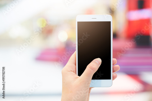 Shot of unrecongnizable woman holds modern smart phone with blank copy black screen for your advertising content or promotional text. Close up of woman`s hand holds generic electronic device