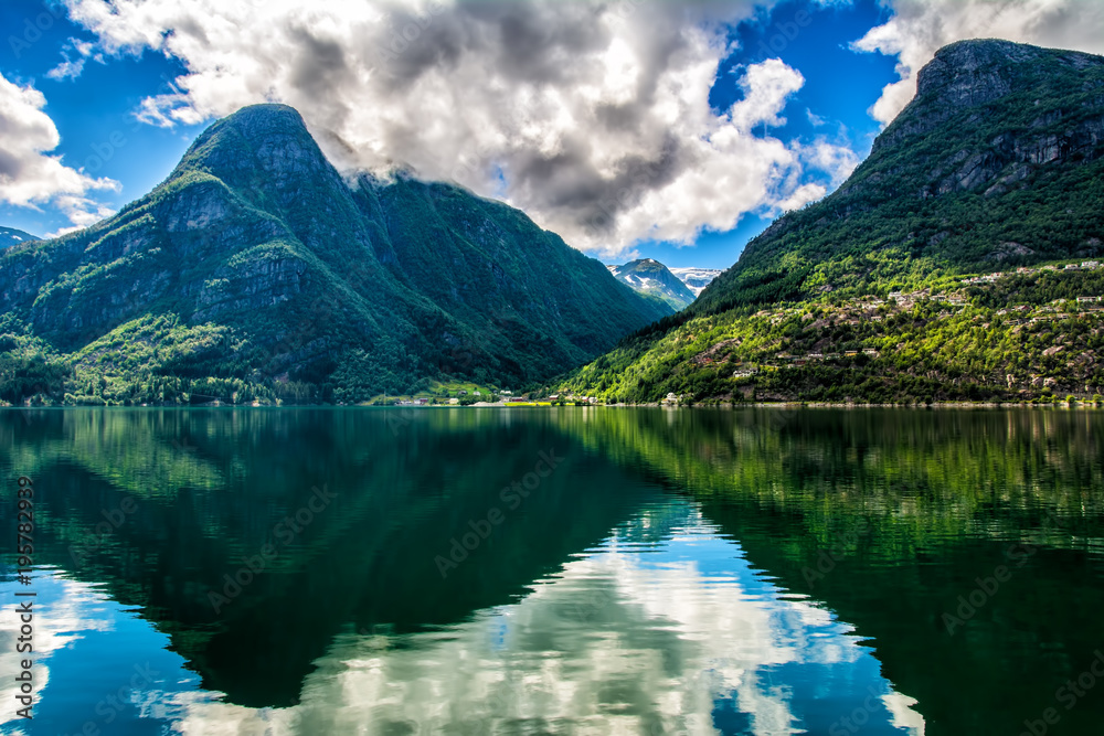 Norway landscapes. The mountains are reflecting in the water of the fjord on a sunny day
