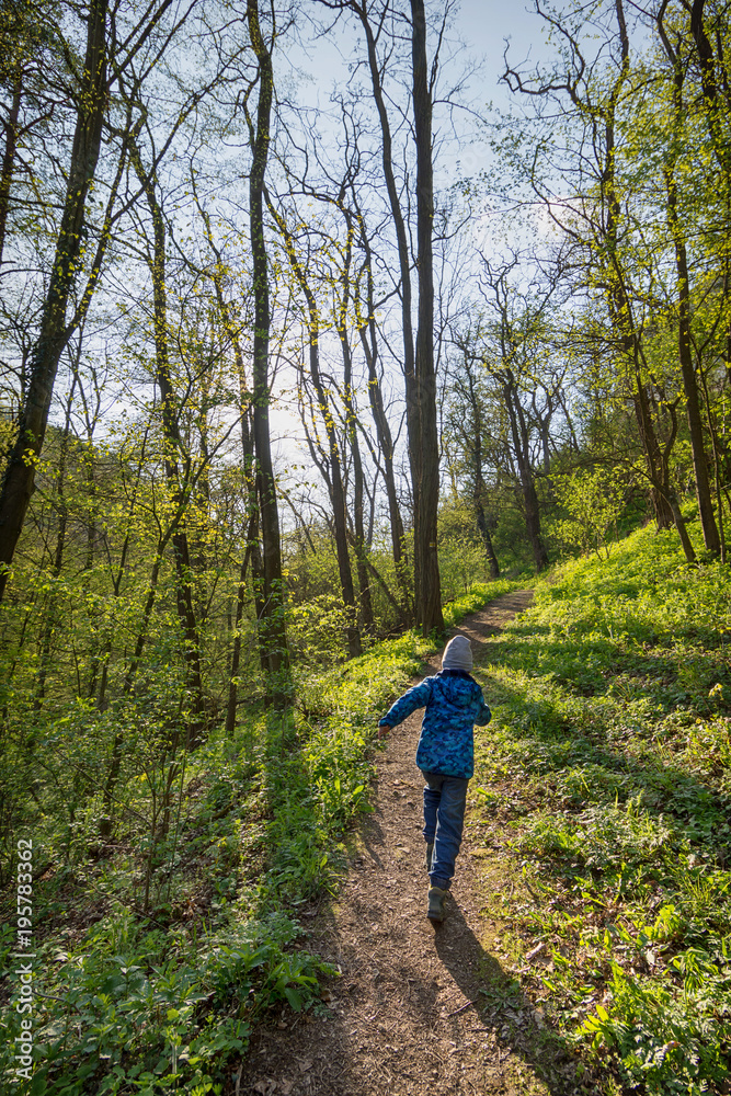 Naklejka premium Child running in spring forest