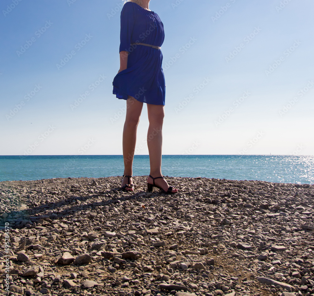 A girl is walking on the beach near the sea
