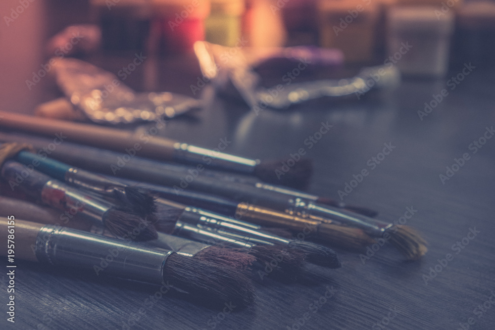 Naklejka premium Artist paint brushes on wooden background, craft art process