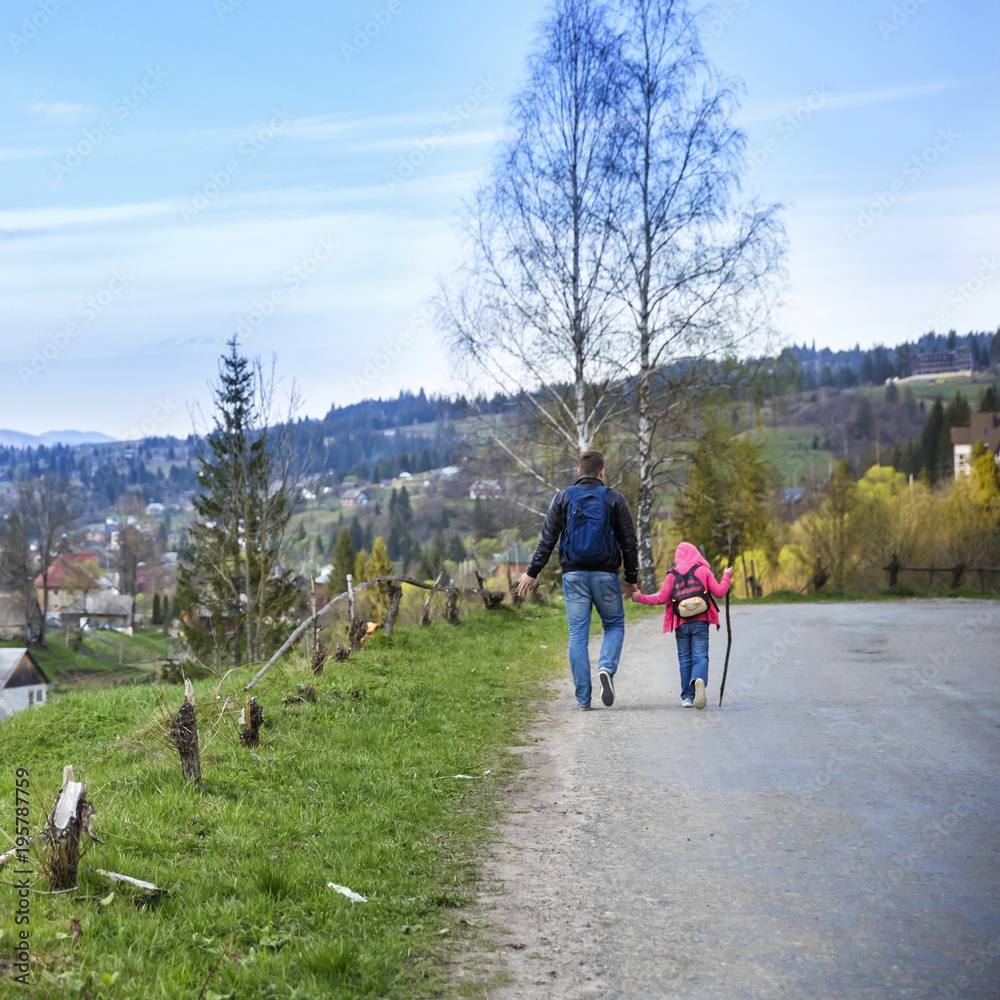 Young father and his adorable little daughter hiking in mountains in beautiful sunny day Young father and his adorable little daughter hiking in mountains in beautiful sunny day