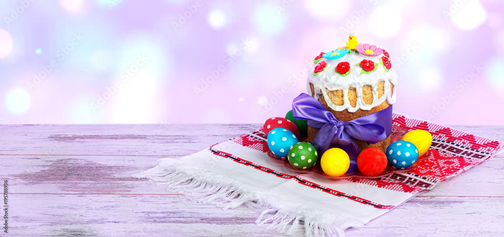 Happy Easter! Easter Cake - Russian and Ukrainian traditional kulich and colorful eggs on an embroidered towel.