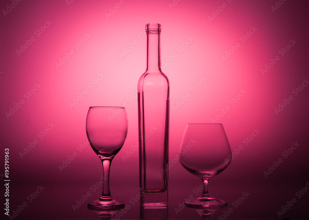 Empty bottle and glasses on a rad graded background Empty bottle and glasses on a rad graded background