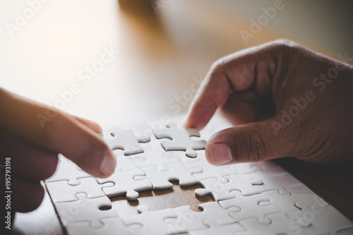 Man hands connecting couple puzzle piece in office. Business solutions, target, successful, goals and strategy concepts