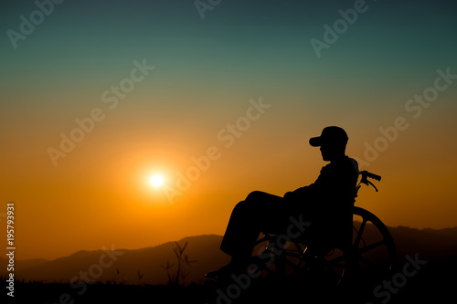 Happy boy in wheelchair on sunset. Happy disabled child concept