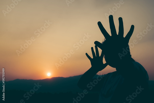 Silhouette young girl with her hand extended signaling to stop at the sunset time. Concept of human rights. © doidam10