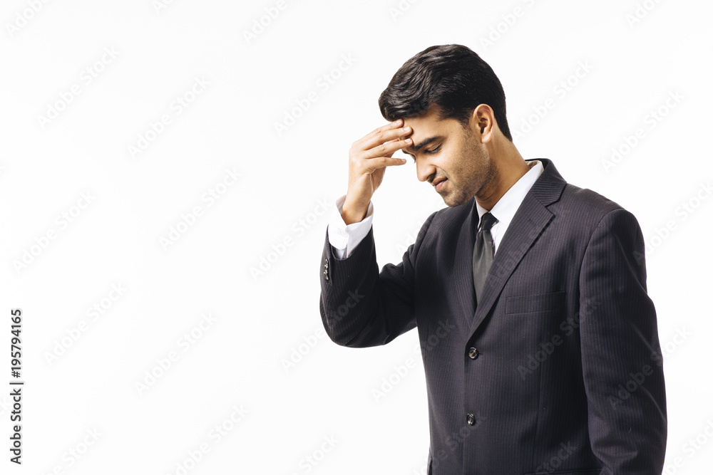 Portrait of an unhappy worried man in business suit and tie, holding forehead, isolated on white studio background Portrait of an unhappy worried man in business suit and tie, holding forehead, isolated on white studio background