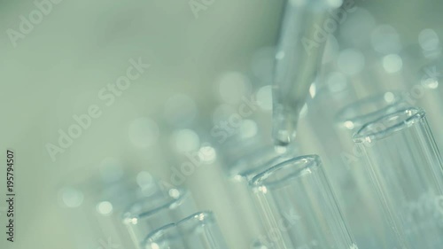 laboratory scientist working with a pipette analyzes and extract the DNA or molecules in the test tubes.on blue background