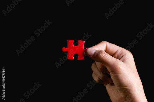 Hand holding piece of blank jigsaw puzzle