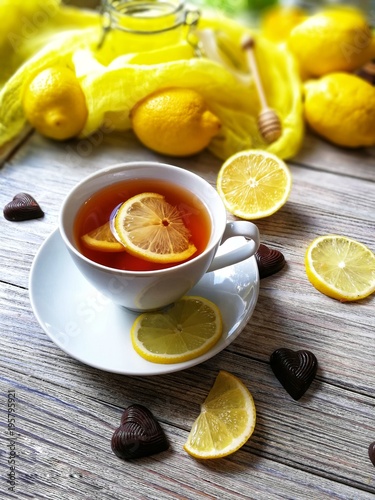 tea with lemons in a rustic style on white wooden background 