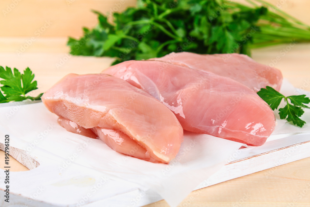 raw chicken fillets on wooden cutting board. raw chicken fillets on wooden cutting board.