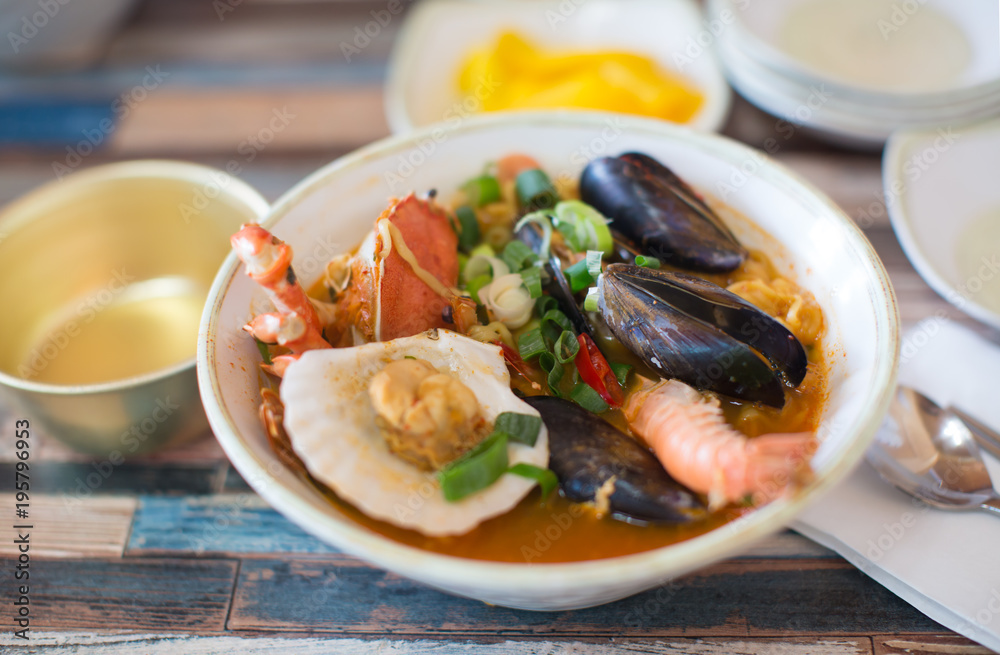 Fototapeta premium Seafood Soup in a Bowl. Shellfish, Shrimp, Green Onions. 